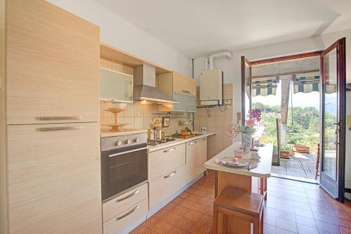 a kitchen with wooden cabinets and a large window at Casa Virginia Apartments in Laveno-Mombello
