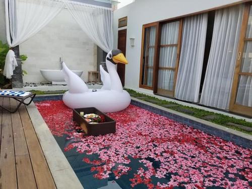 a bathroom with two swans and a bath tub at K Villa in Kerobokan