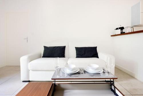 un salon avec un canapé blanc et une table dans l'établissement La Rotonde - Magnifique Appartement climatisé avec parking, à Aix-en-Provence