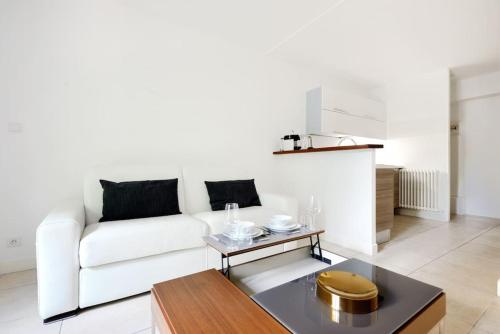 un salon avec un canapé blanc et une table dans l'établissement La Rotonde - Magnifique Appartement climatisé avec parking, à Aix-en-Provence