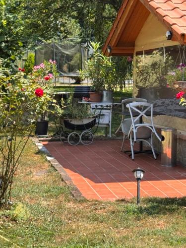 a patio with a table and chairs and flowers at Fonfa Liget in Sénye