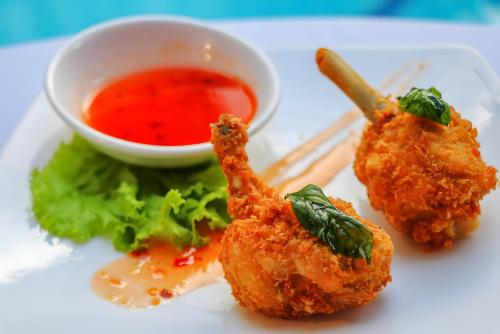 a plate of food with a bowl of dipping sauce at YASODHARAPURA Residence in Siem Reap