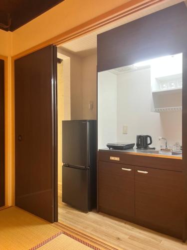 a kitchen with a black refrigerator and a counter at Kyomachiya Daitokuji in Kyoto