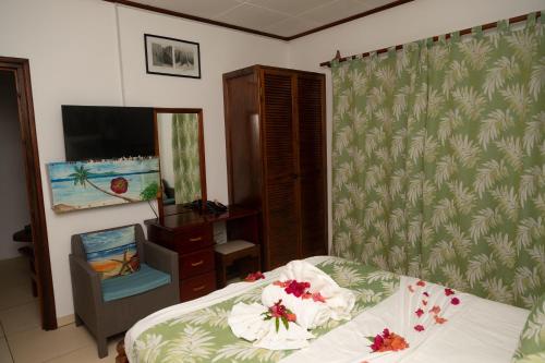 a bedroom with a bed with flowers on it at Pension Hibiscus in La Digue