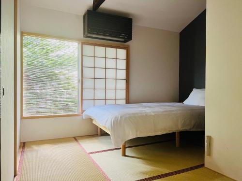 a bedroom with a bed and a window at Kyomachiya Daitokuji in Kyoto