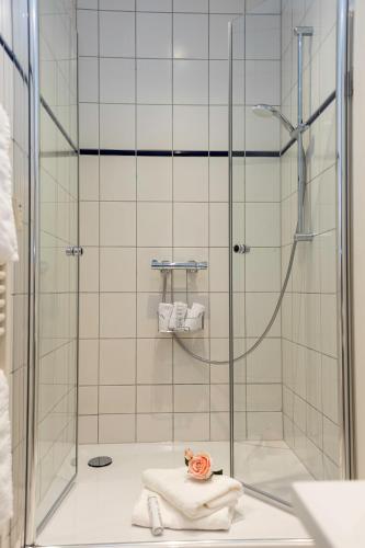 a bathroom with a shower with towels on the floor at Nostalgie-Nest mit Boxspringbett in Mayen