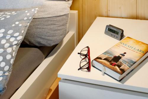 a bedside table with a book and a clock on it at Wellness Ferienwohnung Müller in Rostock