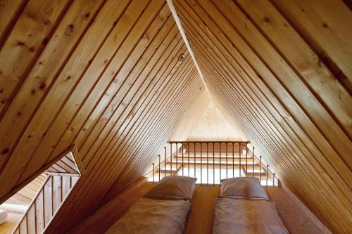 an attic with two beds in a wooden room at Wellness Ferienwohnung Müller in Rostock