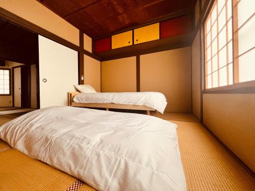 a room with two beds and a window at Kyomachiya Kitayamaomiya in Kyoto
