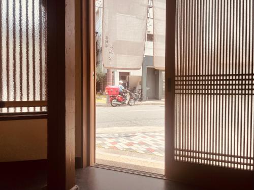 a view from a window of a street with a motorcycle at Kyomachiya Kitayamaomiya in Kyoto