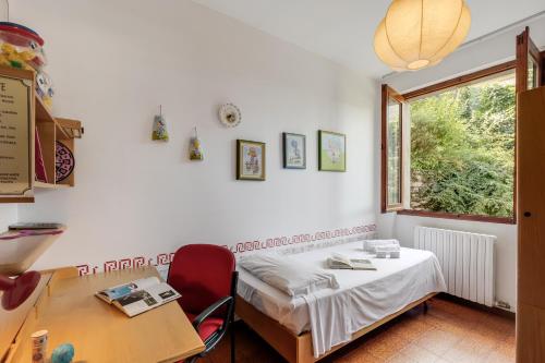 a room with a bed and a table and a window at Casa Virginia Apartments in Laveno-Mombello