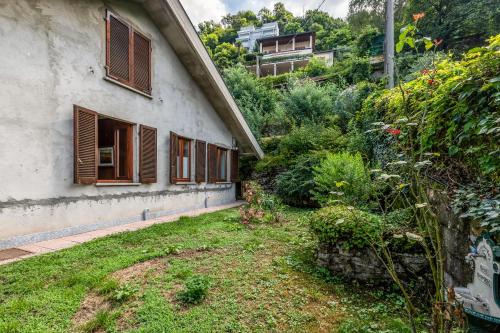 a house with a yard next to a building at Casa Virginia Apartments in Laveno-Mombello