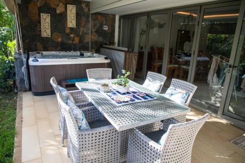 a table and chairs on a patio with a bath tub at 3 Bedroom Apartment in Pereybere