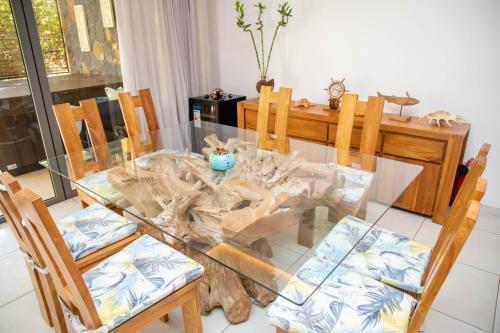 a glass dining room table with chairs and a wooden table at 3 Bedroom Apartment in Pereybere