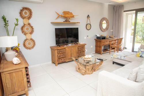 a living room with a couch and a tv at 3 Bedroom Apartment in Pereybere