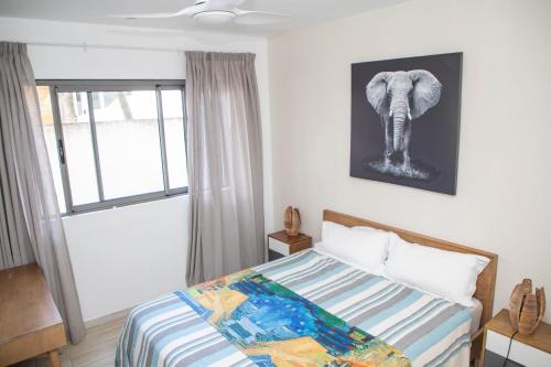 a bedroom with a bed and a picture of an elephant at 3 Bedroom Apartment in Pereybere