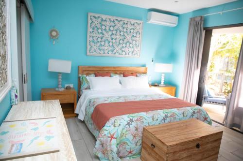 a bedroom with a bed and a blue wall at 3 Bedroom Apartment in Pereybere