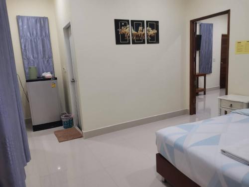 a bedroom with a bed and a white floor at Numhom Resort in Ban Nong Chum Saeng