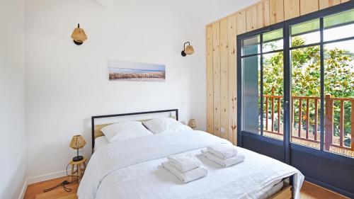 une chambre avec un lit avec des serviettes dessus dans l'établissement Maison 4 chambres, Petit Piquey, à Lège-Cap-Ferret