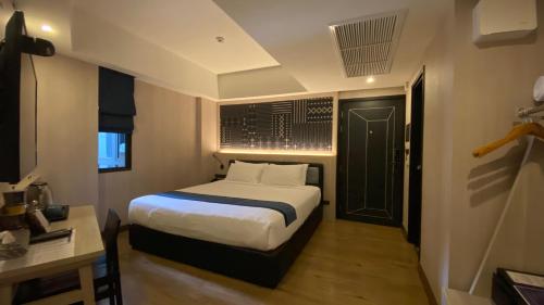 a bedroom with a bed and a black door at Salee Boutique Hotel in Chiang Mai