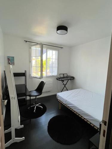 une chambre avec un lit, une chaise et une fenêtre dans l'établissement Maison de plain-pied au calme avec piscine, à LʼHoumeau