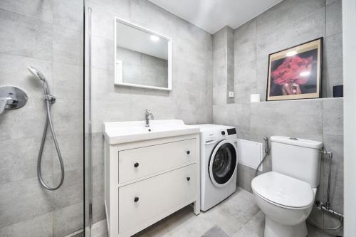 a bathroom with a toilet and a washing machine at Apartment in Trakai by the lake! in Trakai