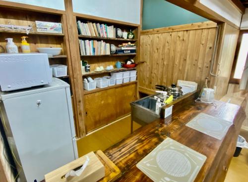 a kitchen with a wooden counter and a refrigerator at 一棟貸切コンパクトハウス 黒川温泉まで車で10分 TAO flow in Minamioguni