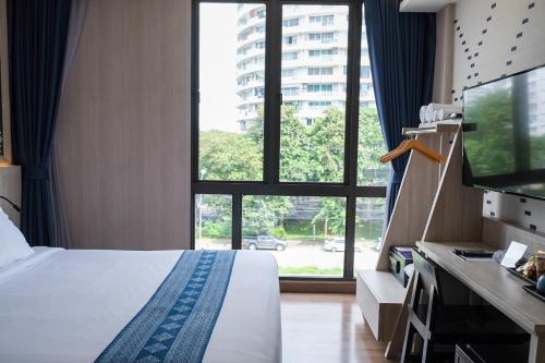 a hotel room with a bed and a large window at Salee Boutique Hotel in Chiang Mai
