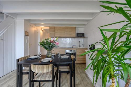 une cuisine et une salle à manger avec une table et des chaises noires dans l'établissement L'Appel du Large - Duplex vue mer Penvins Sarzeau, à Sarzeau