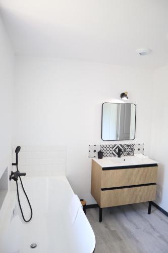 une chambre avec un lit blanc et un miroir dans l'établissement Le domaine des figuiers - Gîte des pèlerins, à Servon