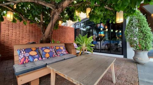 a wooden bench sitting in front of a building at Salee Boutique Hotel in Chiang Mai