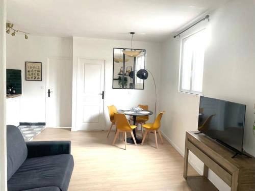 a living room with a couch and a table with chairs at #7 Appartement pour 5 personnes près du métro L9 in Bagnolet