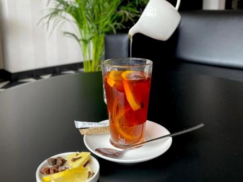 a drink on a table with a plate of food at Hotel Swing in Kraków