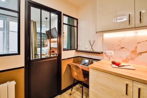 Il comprend une cuisine avec un bureau et une chaise. dans l'établissement WS Champs-Elysées - Daru, à Paris