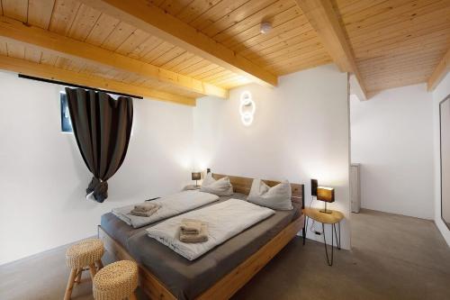 a bedroom with a bed with white walls and wooden ceilings at Ferienoase Im Land Der 1000 Seen in Karstädt