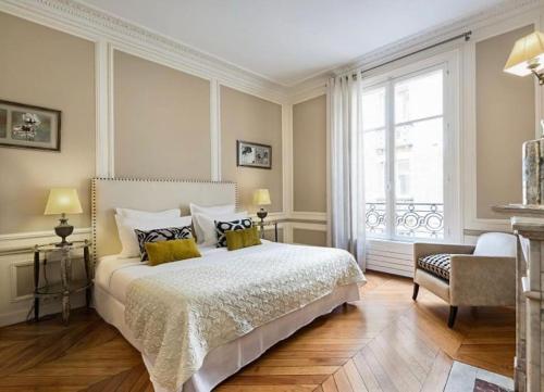 une chambre avec un grand lit et une fenêtre dans l'établissement Invalides Pont Alexandre III Luxury Apartement 2BR, à Paris