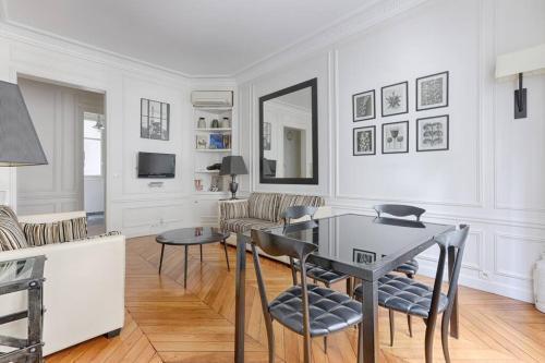 un salon blanc avec une table et des chaises dans l'établissement Invalides Pont Alexandre III Luxury Apartement 2BR, à Paris