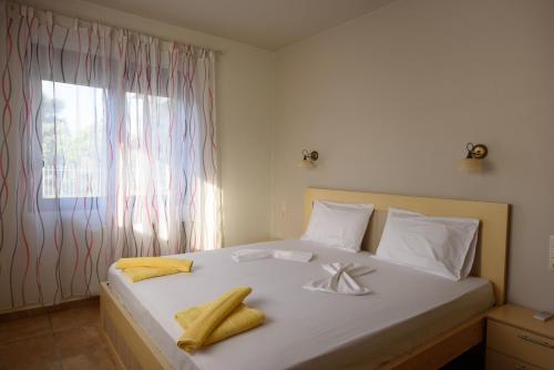a bedroom with a bed with towels on it at Apartment Mythos Myrto in Pitsidia