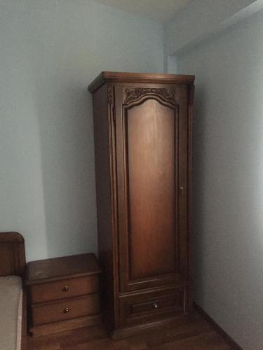 a wooden cabinet in the corner of a bedroom at Anga Yerevan Apartments in Yerevan