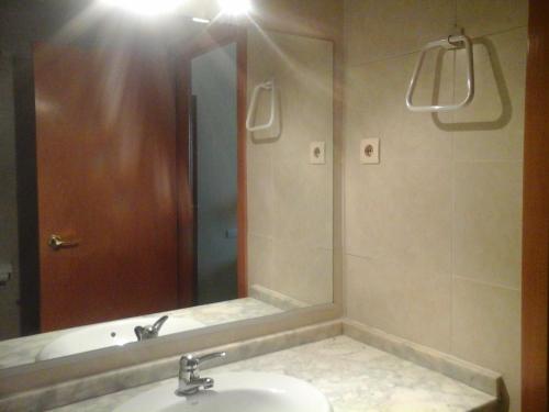 een badkamer met een wastafel en een grote spiegel bij Apartament Fira in Hospitalet de Llobregat