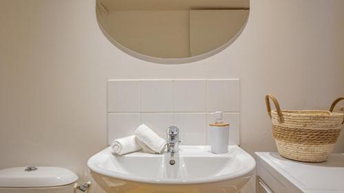 une salle de bain blanche avec un lavabo et un miroir dans l'établissement Le Trinité Loft, à Troyes
