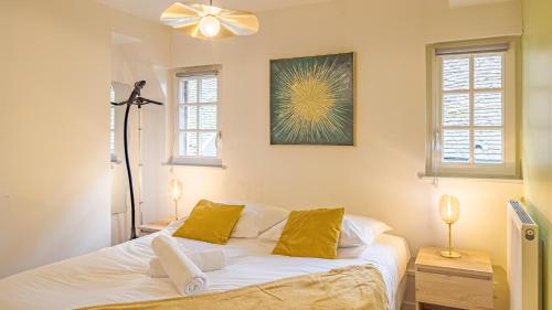 une chambre avec un lit blanc avec des oreillers jaunes dans l'établissement Le Trinité Loft, à Troyes