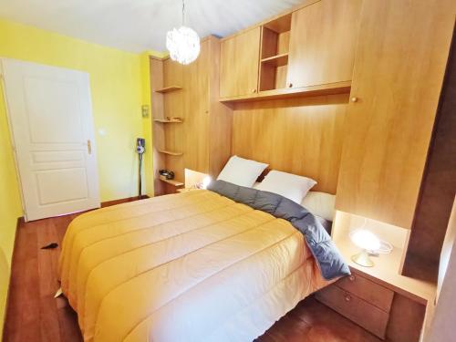 a bedroom with a large bed with a wooden wall at Le nid d'oeillet, T3 bis, wifi, jardin commun in Luchon