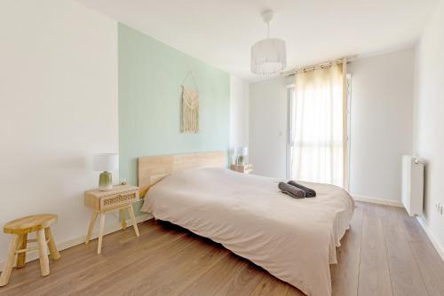 - une chambre avec un lit, une table et un tabouret dans l'établissement T3 avec terrasse et parking, à proximité de l'Aéroport et d'Airbus, à Toulouse