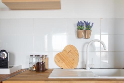 un comptoir de cuisine avec une planche à découper en forme de cœur et un évier dans l'établissement T3 avec terrasse et parking, à proximité de l'Aéroport et d'Airbus, à Toulouse