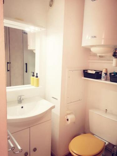 une salle de bain blanche avec un lavabo et des toilettes dans l'établissement Appartement 600M de la plage, à Port-la-Nouvelle