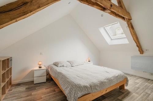 Un dormitorio blanco con una cama y dos lámparas. en Dépendance au charme local, en Saint-Carné
