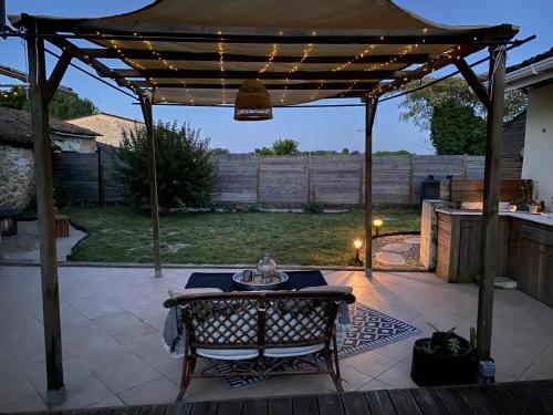 a wooden pergola with a table on a patio at Les atypiques in Preignac