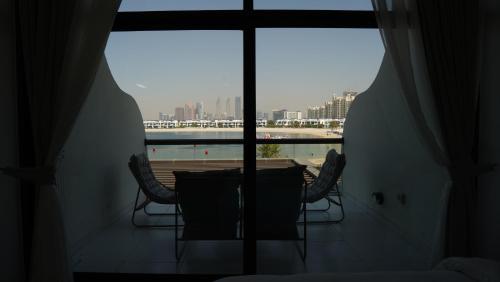 a table and chairs in a room with a window at Dimorelux l Club Vista Mare l Five Palm Jumeirah in Dubai