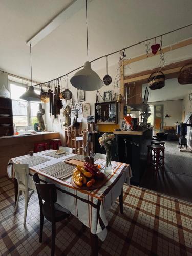 une cuisine avec une table et des chaises dans une pièce dans l'établissement Le Couvent, à LʼHermenault